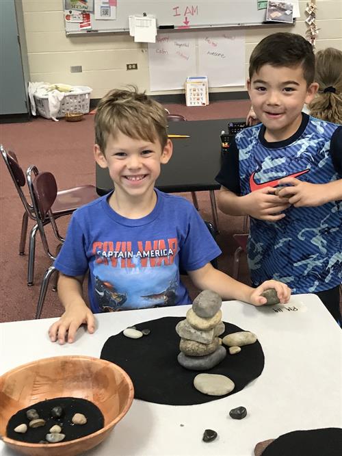 Students attempt to stack rocks in one activity as they learn to calm their minds and thoughts. 